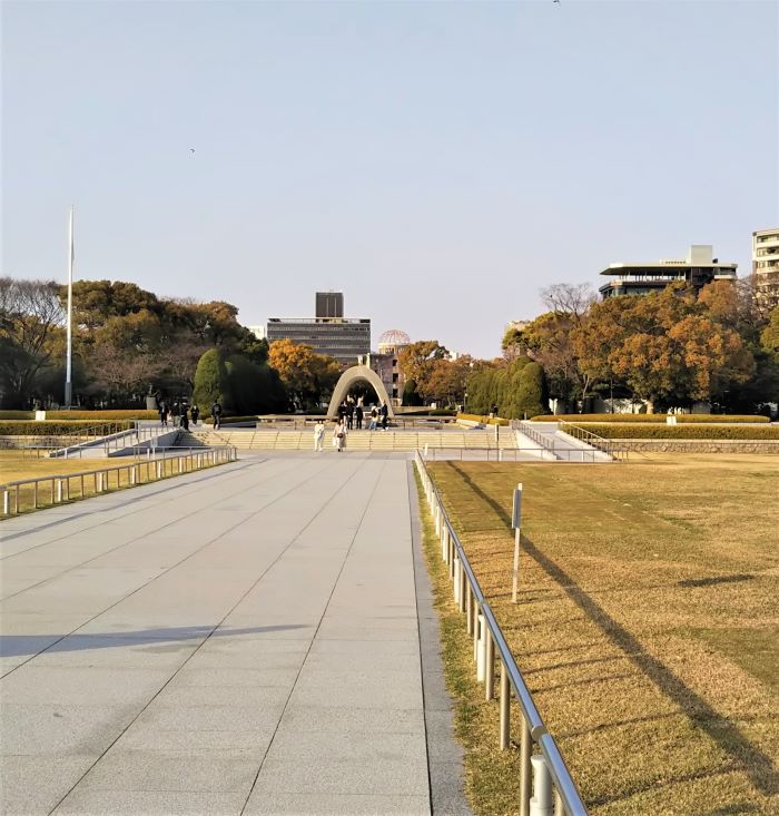 Cenotaph in Hiroshima Peace Memorial Park with the Atomic Bomb Dome in the background