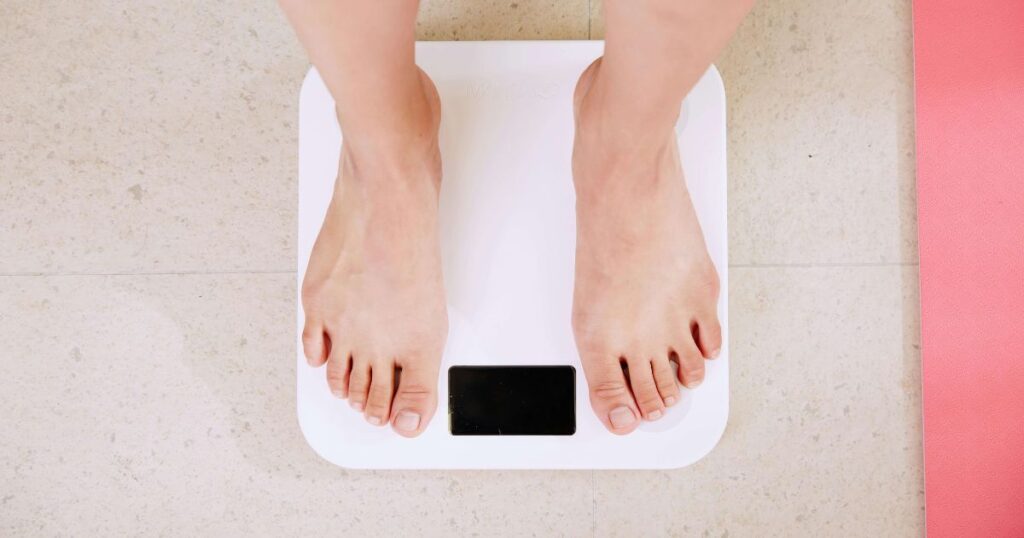 person standing on a scale showing weight gain