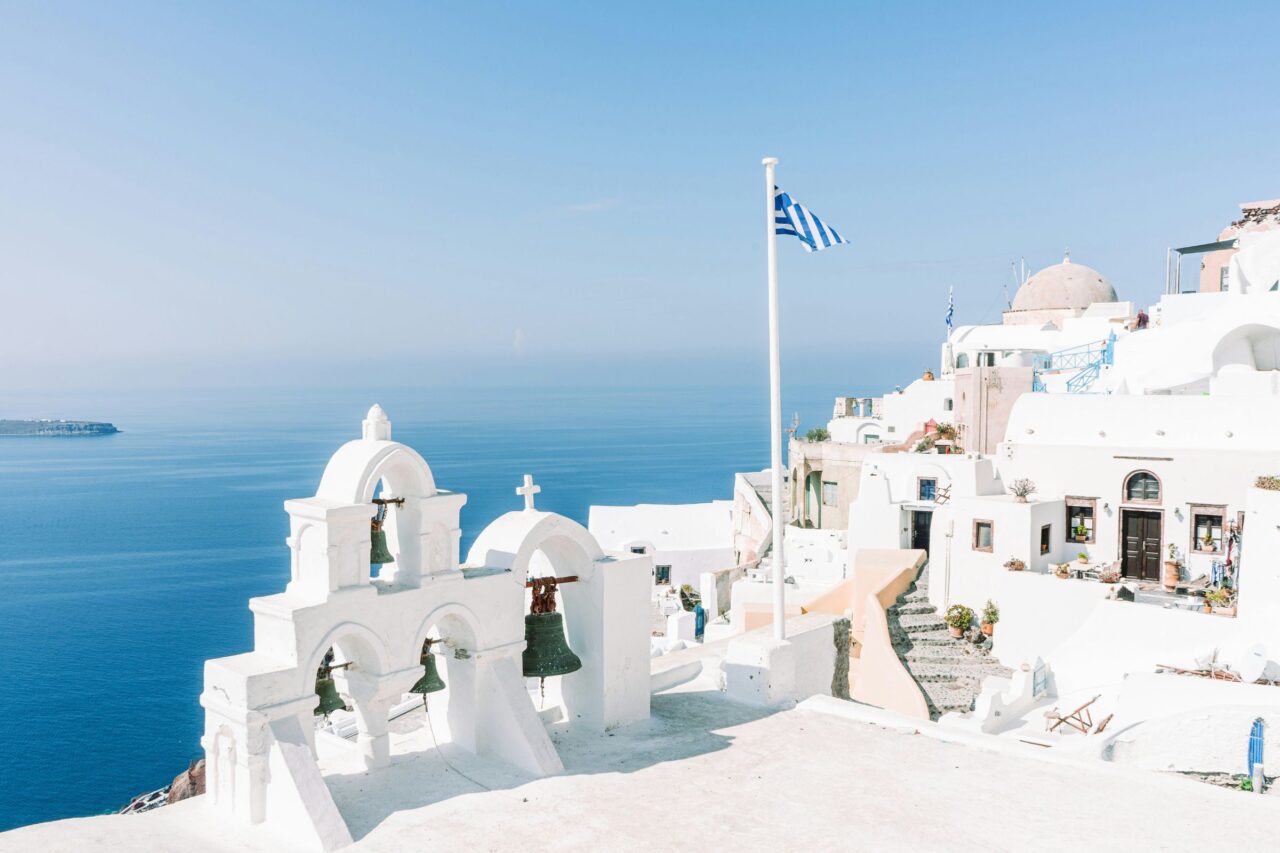 White buildings and a blue sea under clear light.
