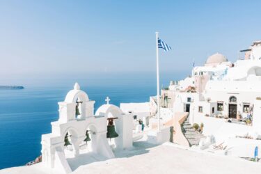 White buildings and a blue sea under clear light.