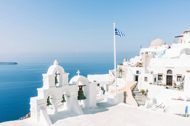 White buildings and a blue sea under clear light.