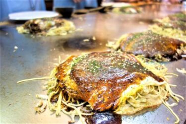 Hiroshima-style okonomiyaki cooked on a hot griddle