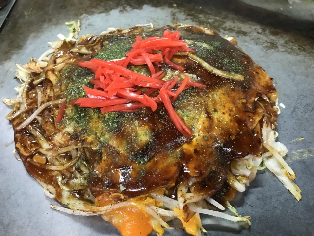 Hiroshima-style okonomiyaki cooked on a hot griddle